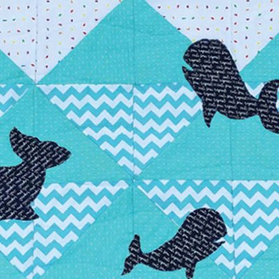 : photo of a youth quilt project with half square triangles and whale