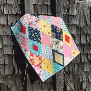 scrappy diamond quilt designed by jackie white and made with the sew easy half diamond ruler