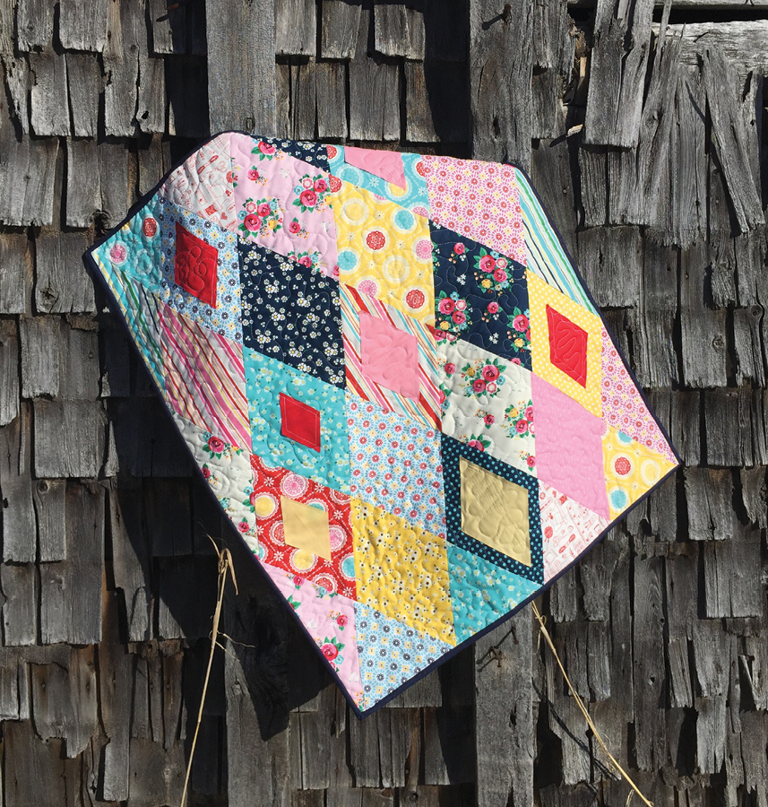 scrappy diamond quilt designed by jackie white and made with the sew easy half diamond ruler