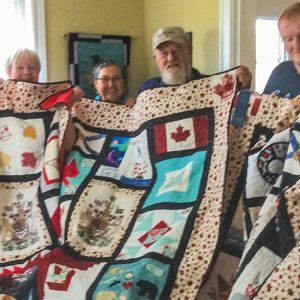 photo of five families receiving quilt for fallen soldiers from the northumberland quilt guild in nova scotia