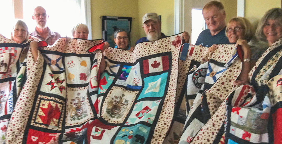 photo of five families receiving quilt for fallen soldiers from the northumberland quilt guild in nova scotia