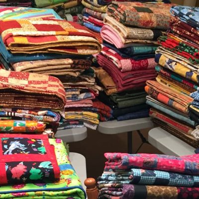 photo of stacks of charity quilts made for canada 150