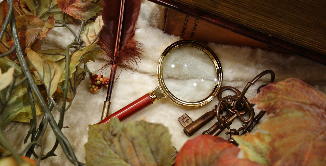 photo of a magnifying glass amid leaves and berries