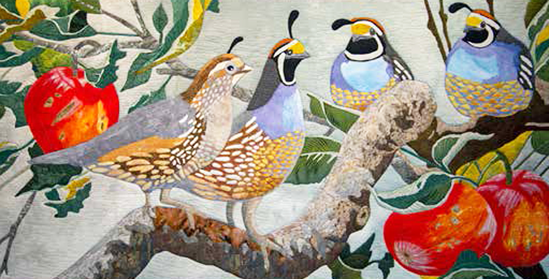 photo of an art quilt of four birds in an apple tree
