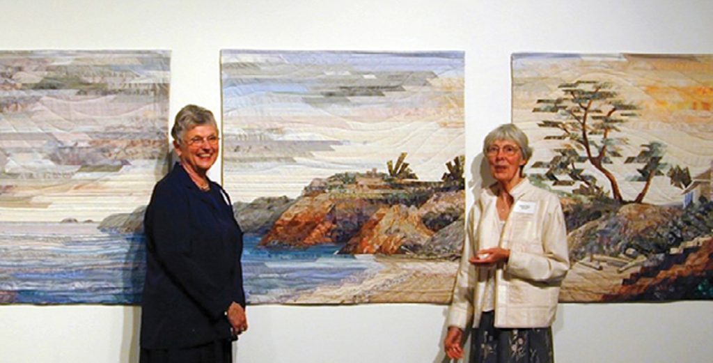 photo of two women in front of a quilt art triptych