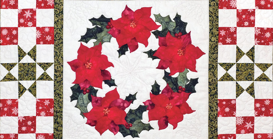 photo of a ring of appliquéd poinsettias surrounded by ohio star and nine patch blocks