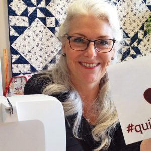 photo of laura coia holding an i love quilt canada sign