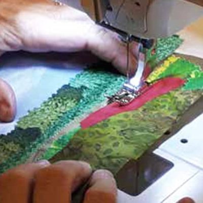 photo of a fabric postcard being sewn