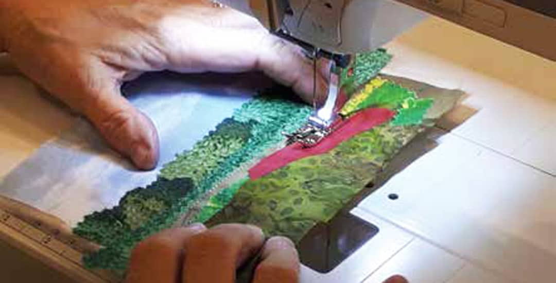 photo of a fabric postcard being sewn
