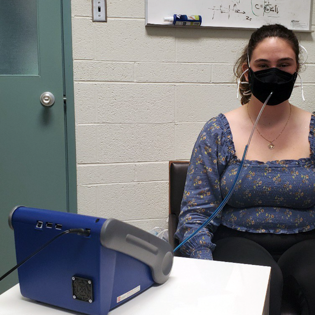 A volunteer wears a test mask connected to a Portacount machine.